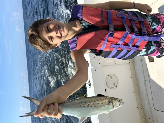 Kid holding up a Spanish mackerel catch
