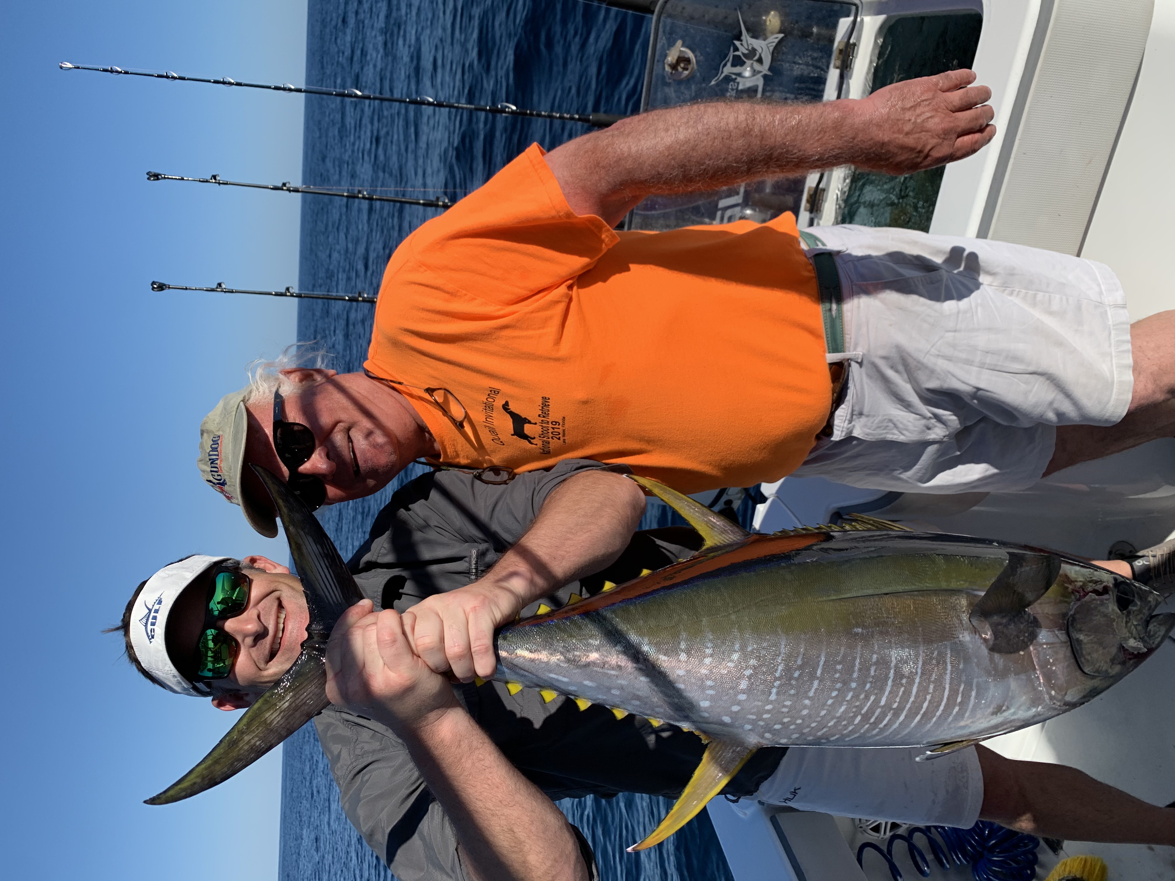 Two anglers holding a large yellowfin tuna